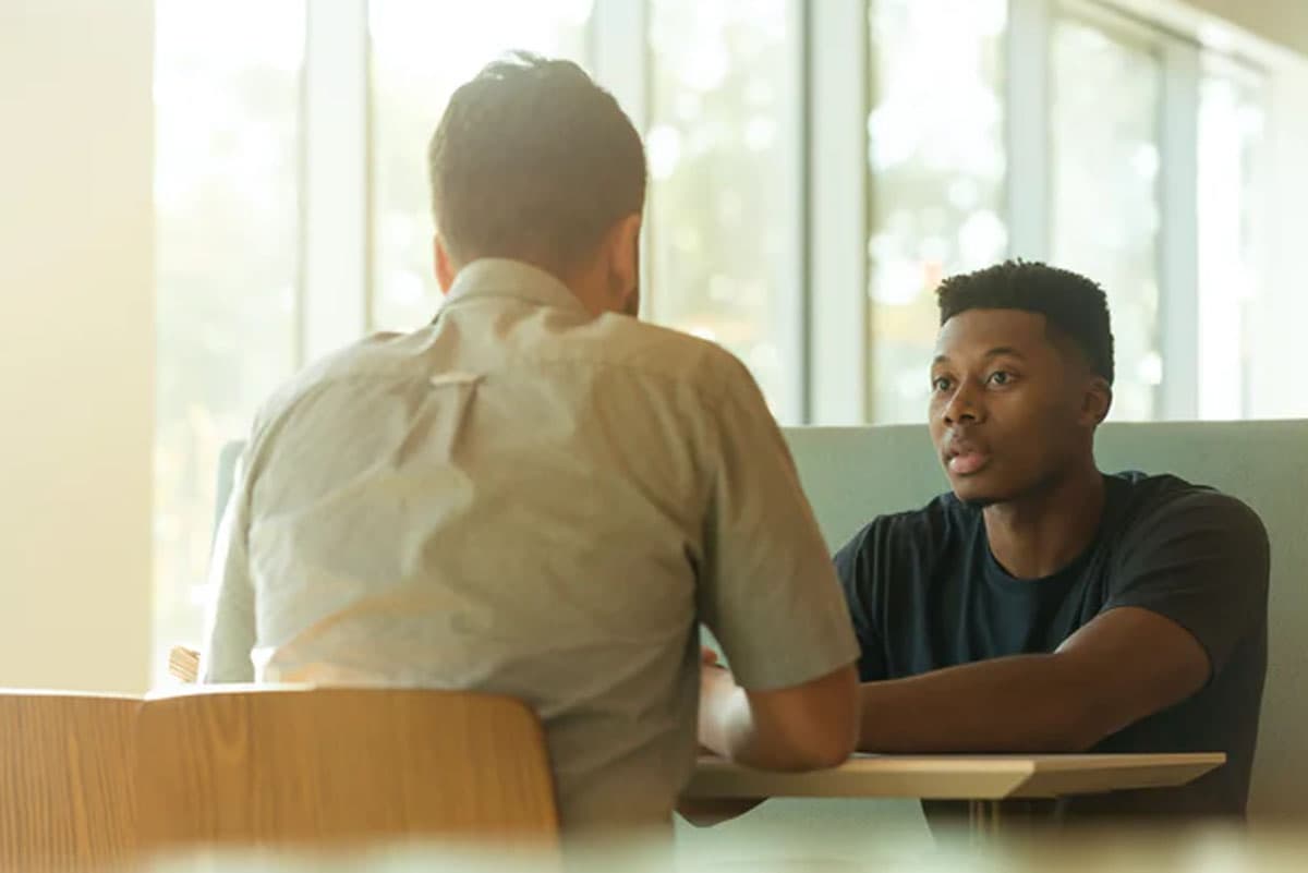 Two men talk a table