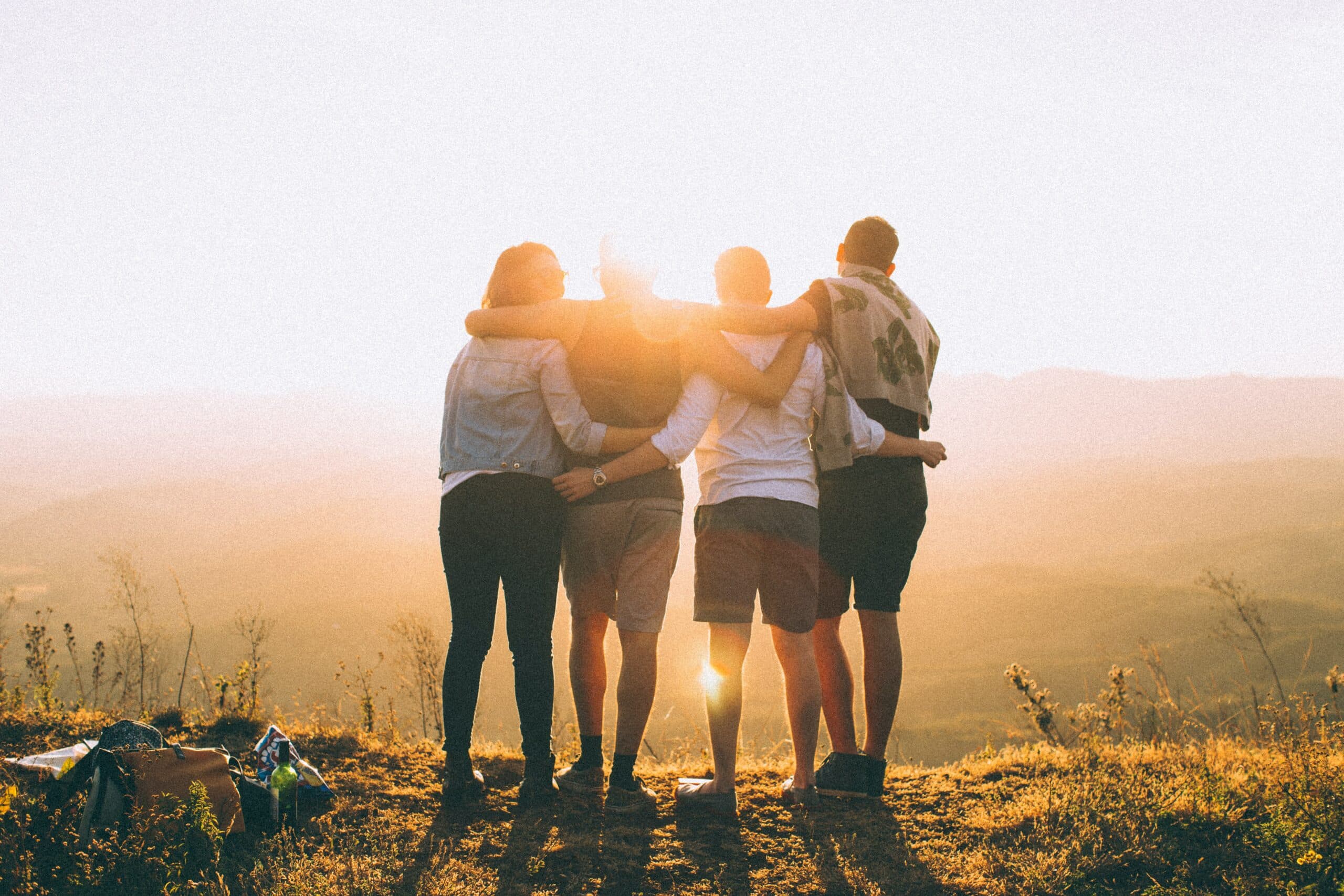 group of four watching a sunrise after a hike