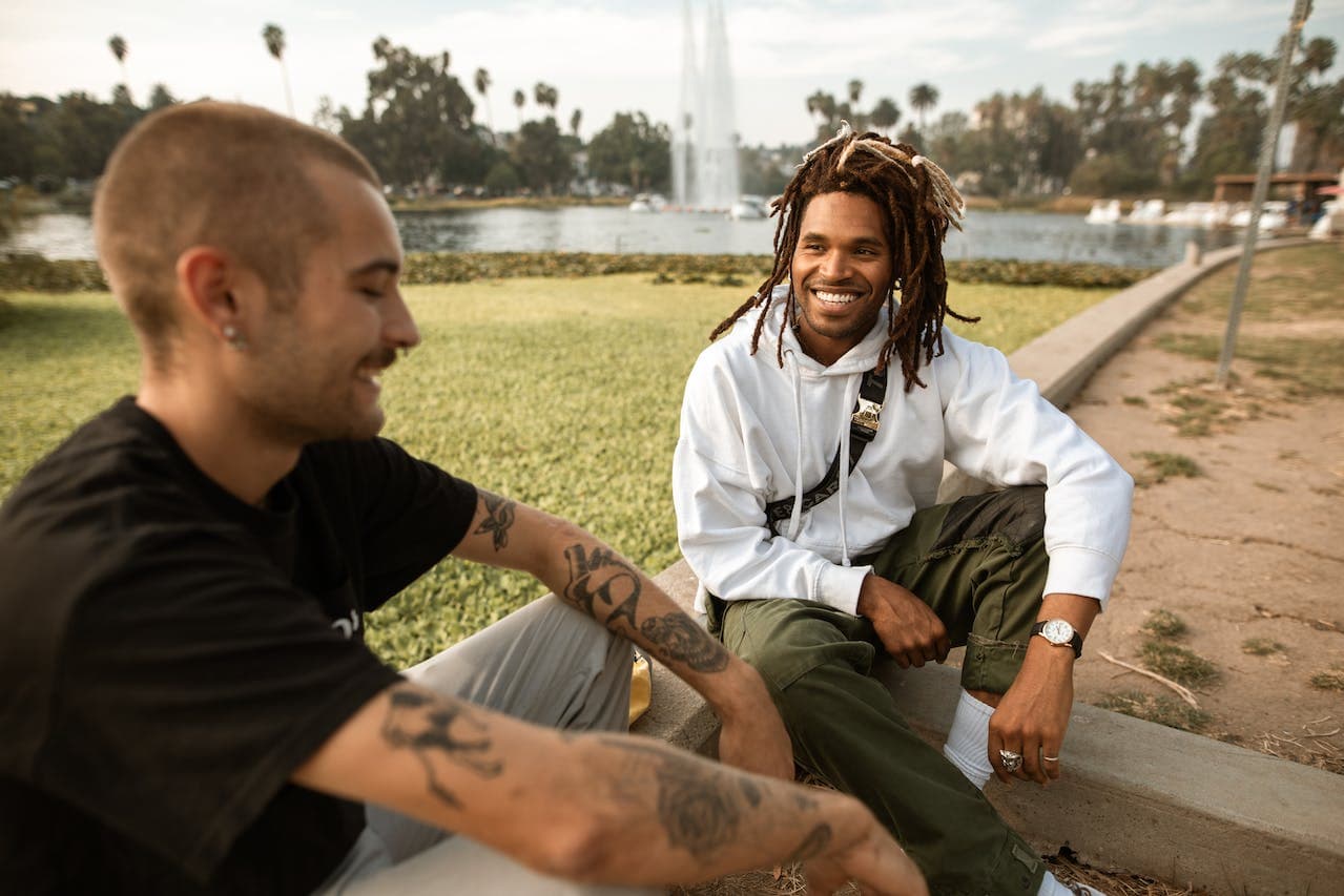 Two men smiling and talking in a park