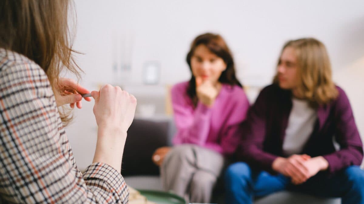 young couple sitting across from counselor