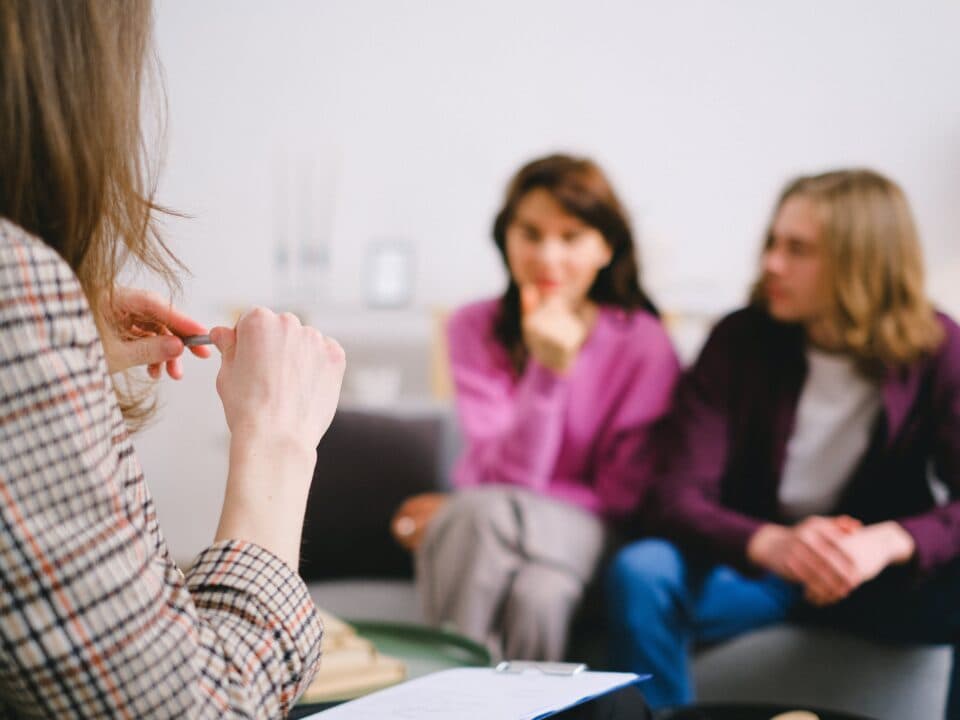 young couple sitting across from counselor