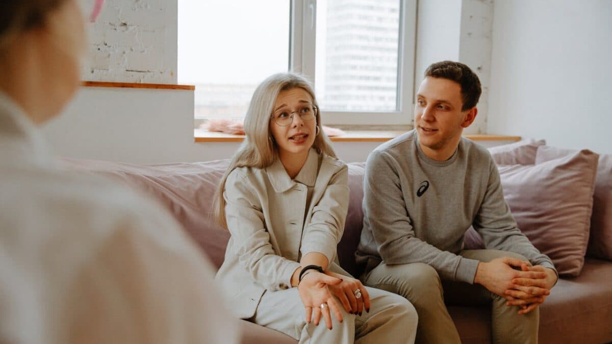 two people on couch talking with counselor