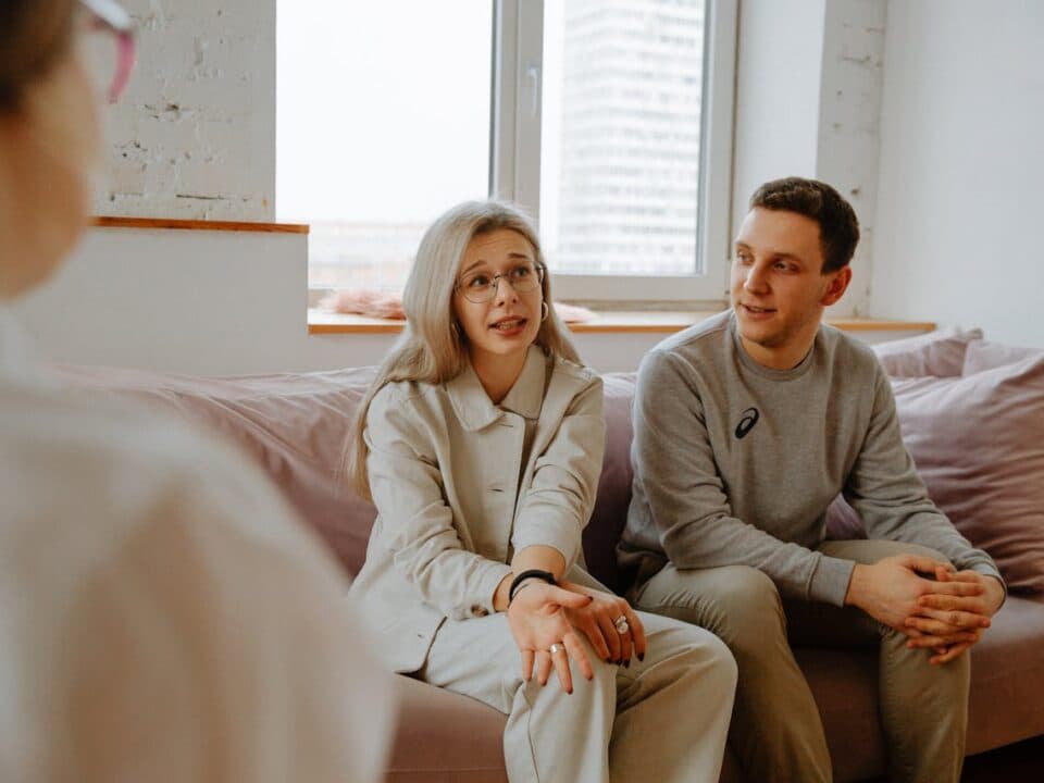 two people on couch talking with counselor