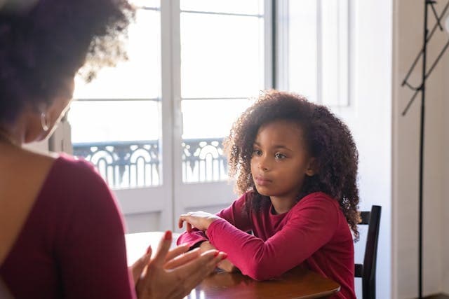 A little girl listening to her mother speak